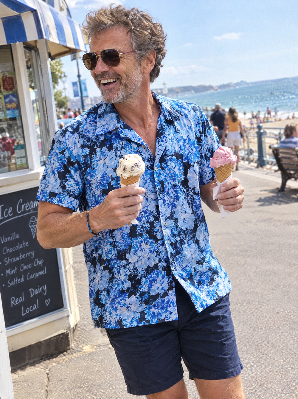 Man wearing The Blue Camellia Short Sleeve shirt at a seaside ice cream kiosk