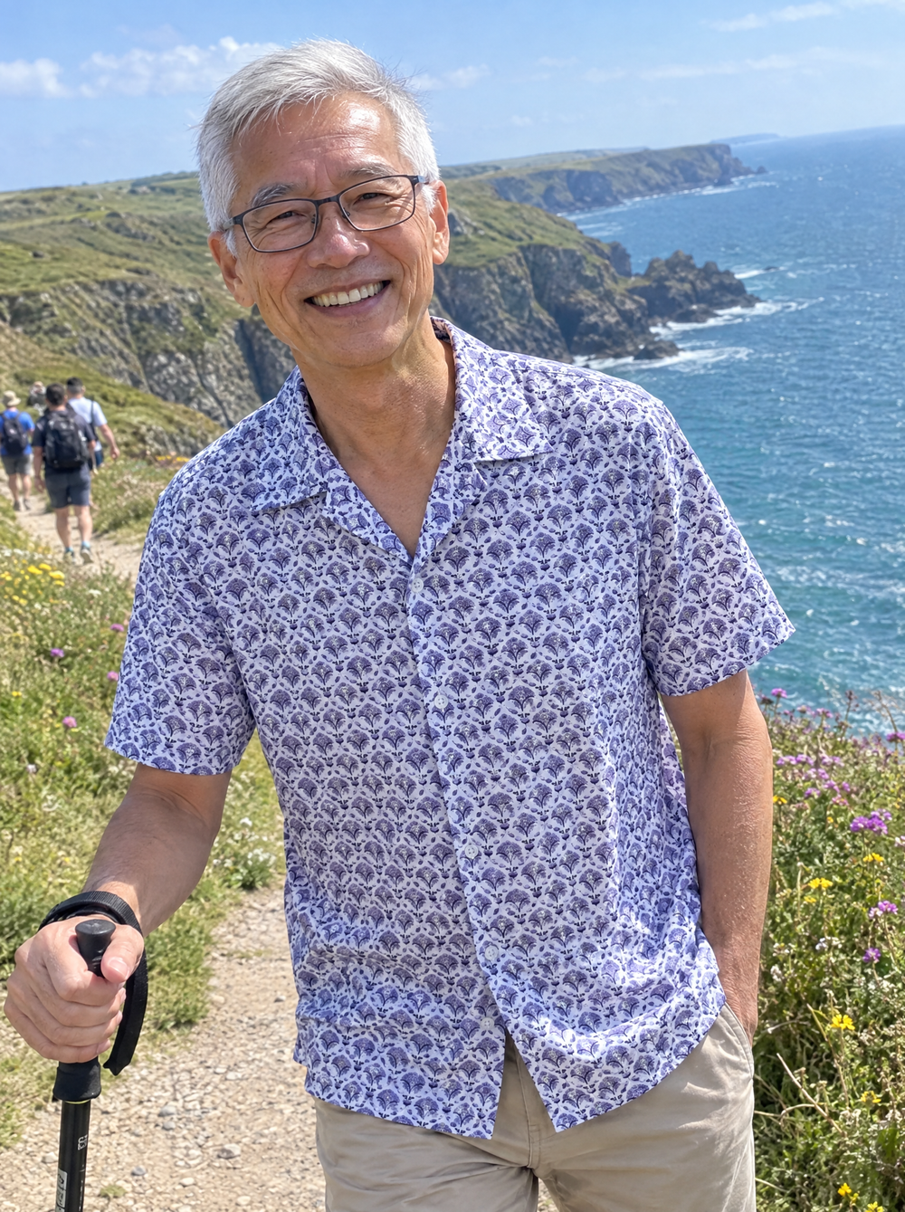 Man wearing the Blue Geo Flora Open Collar shirt on a coastal cliff path