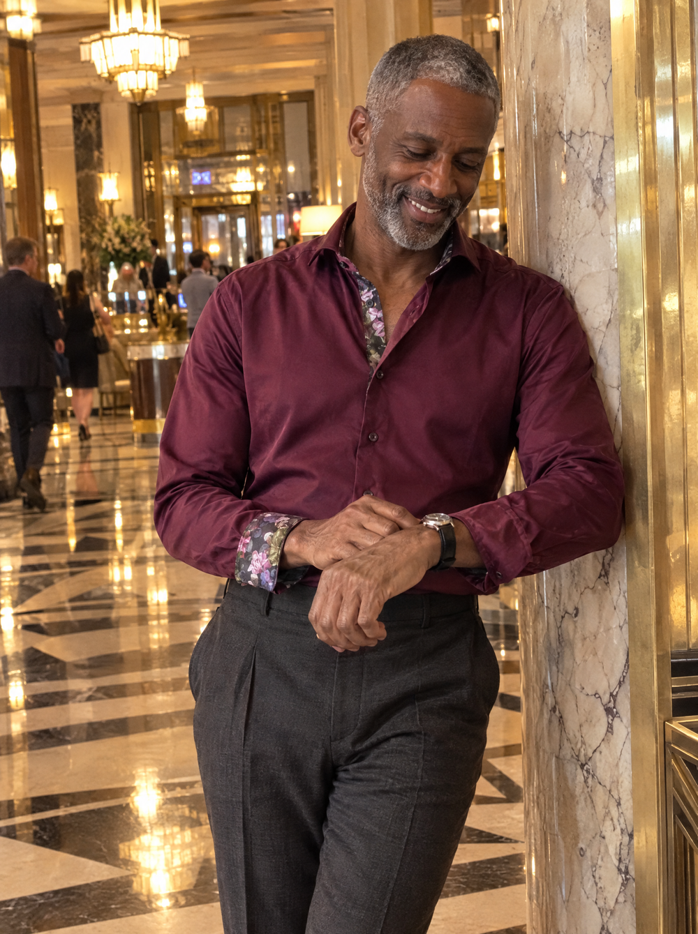 Man wearing the Burgundy Sateen shirt with Roses Accents in an art deco hotel lobby