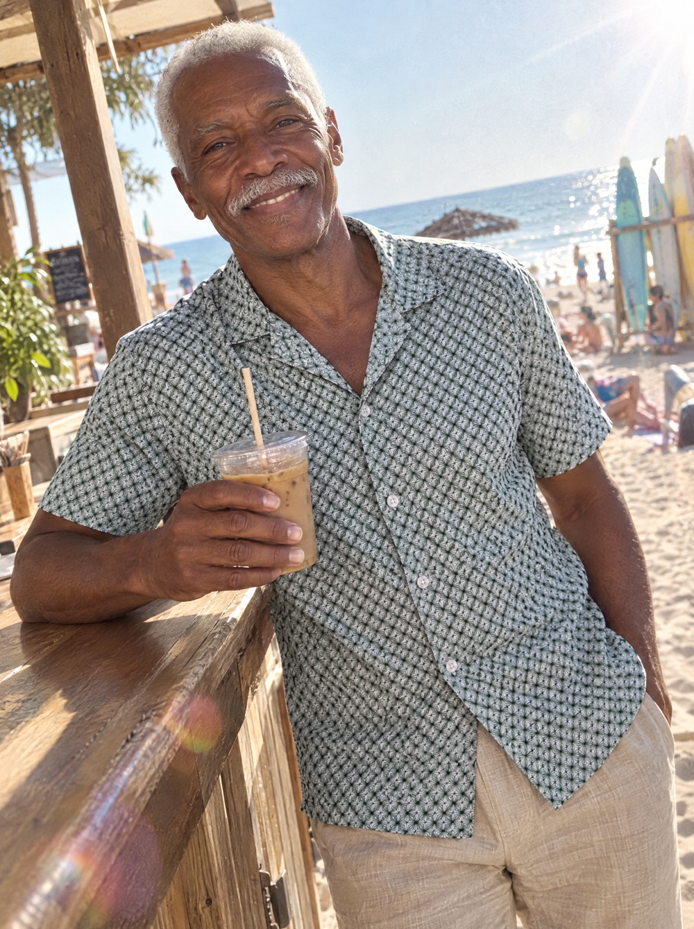 Man wearing the Emerald Wavy Geo Open Collar shirt at a beach café