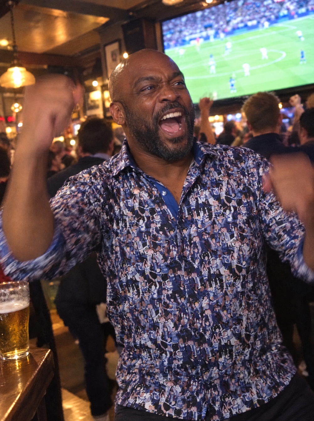 Man wearing the Matchday (Blue) Shirt celebrating a goal in a pub