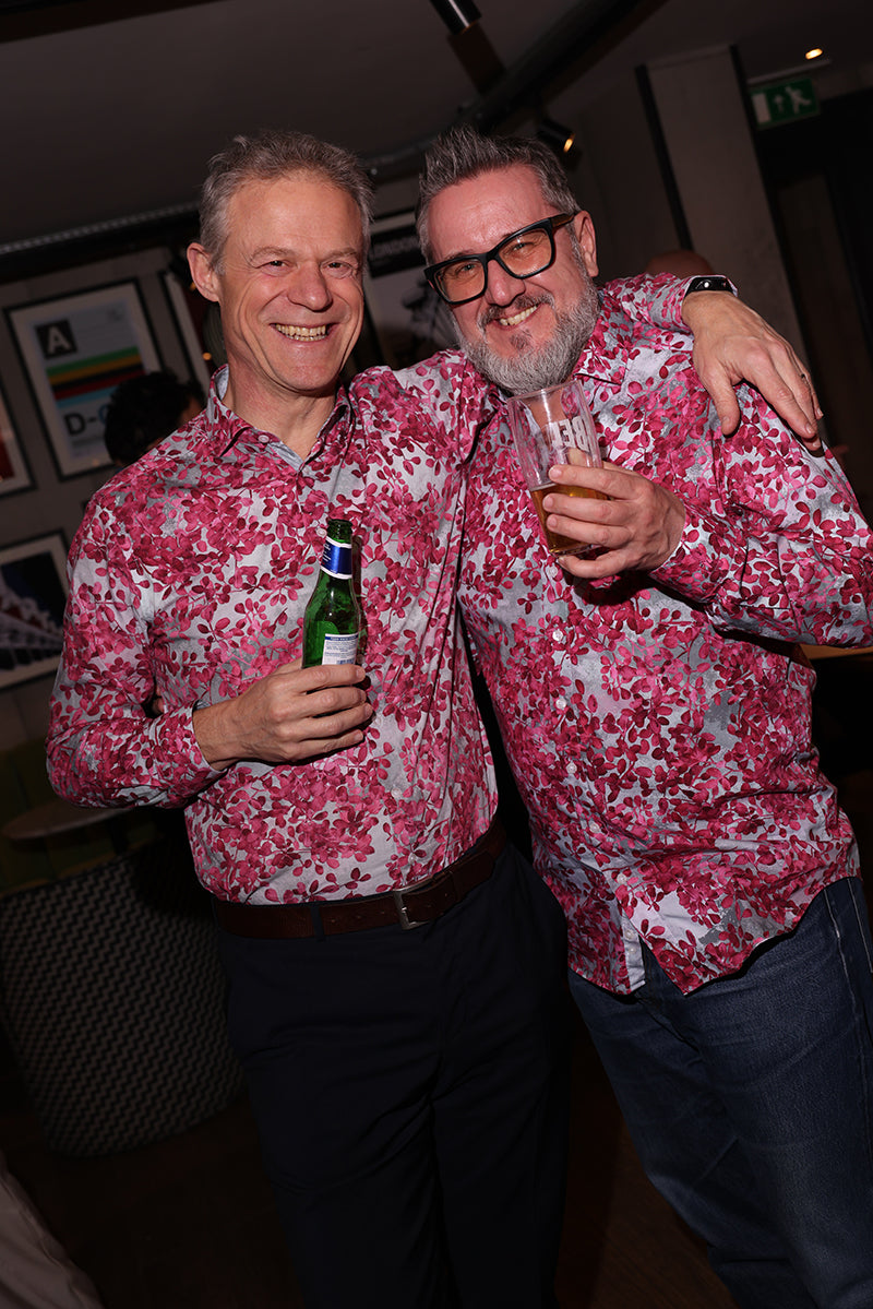 Two guests wearing matching pink patterned shirts at a Blake Mill event
