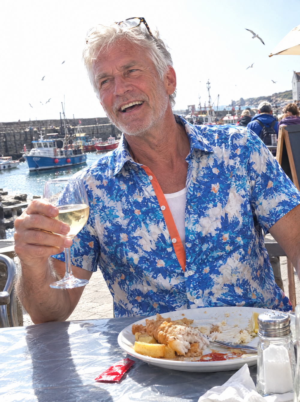 Man wearing the Aegean Bloom Short Sleeve Shirt at a harbourside café