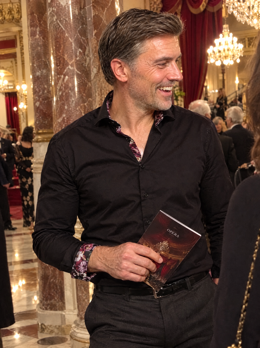 Man wearing the Black Sateen Shirt with Name of the Rose Accents in an opera house foyer