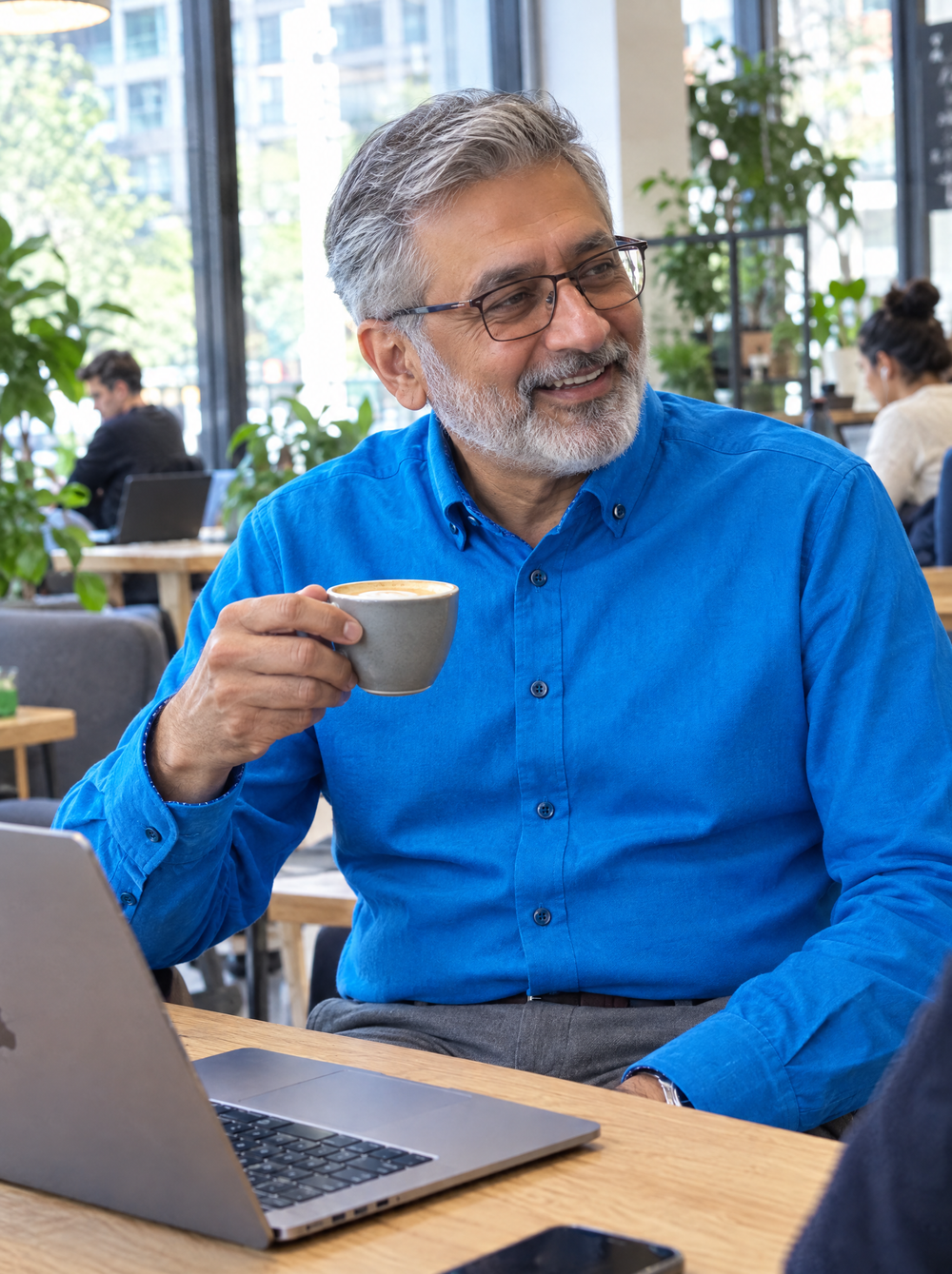 Man wearing the Cobalt Blue Oxford button-down shirt in a co-working café
