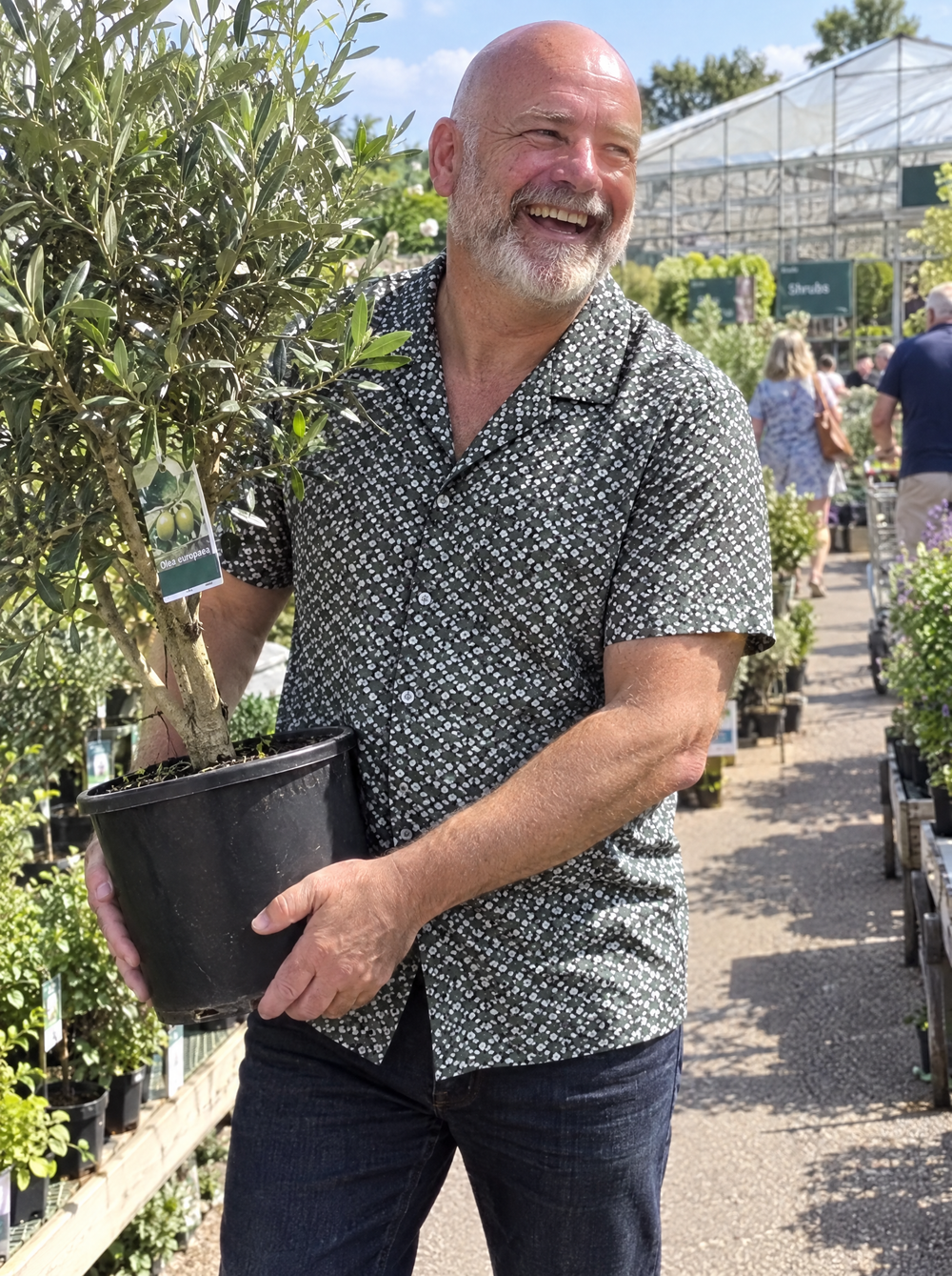 Man wearing the Green Botanic Geo Open Collar shirt at a garden centre