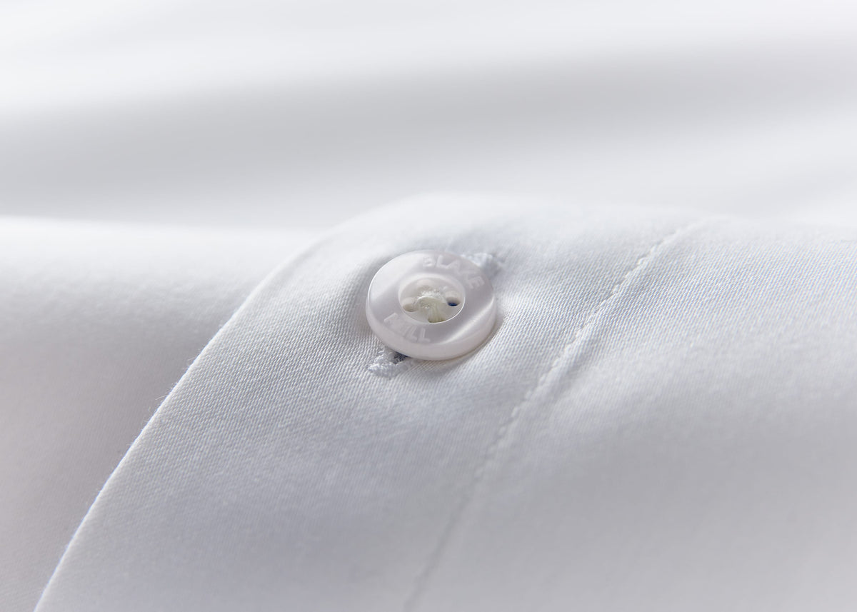 Close-up of a button on white shirt fabric