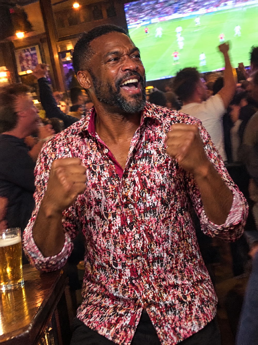 Man wearing the Matchday (Red) shirt celebrating in a pub