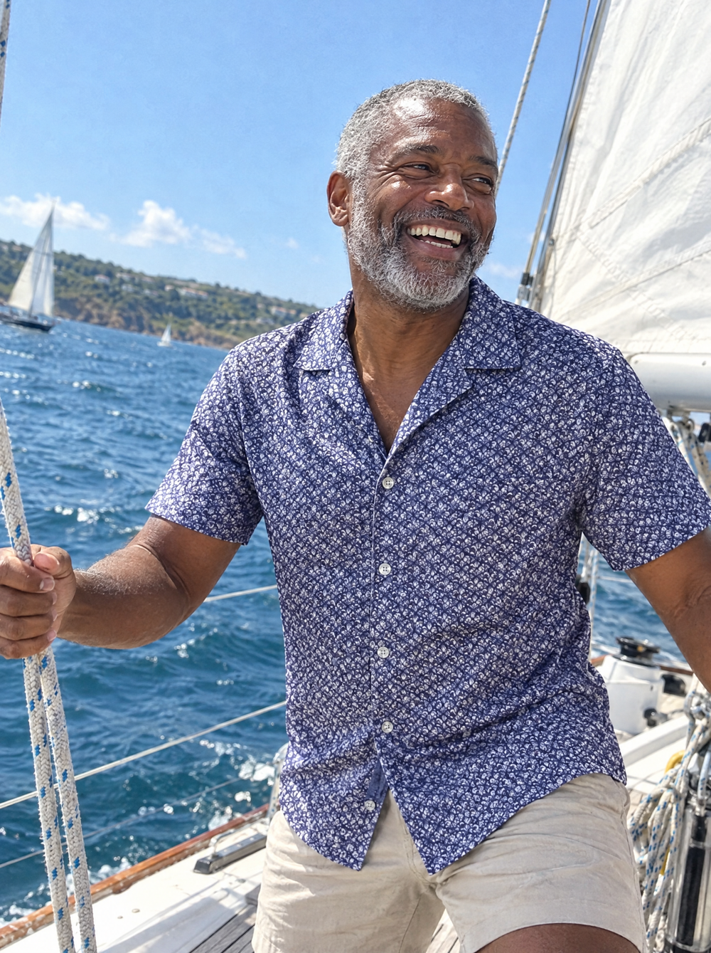 Man wearing the Navy Botanic Geo Open Collar shirt on a sailing boat