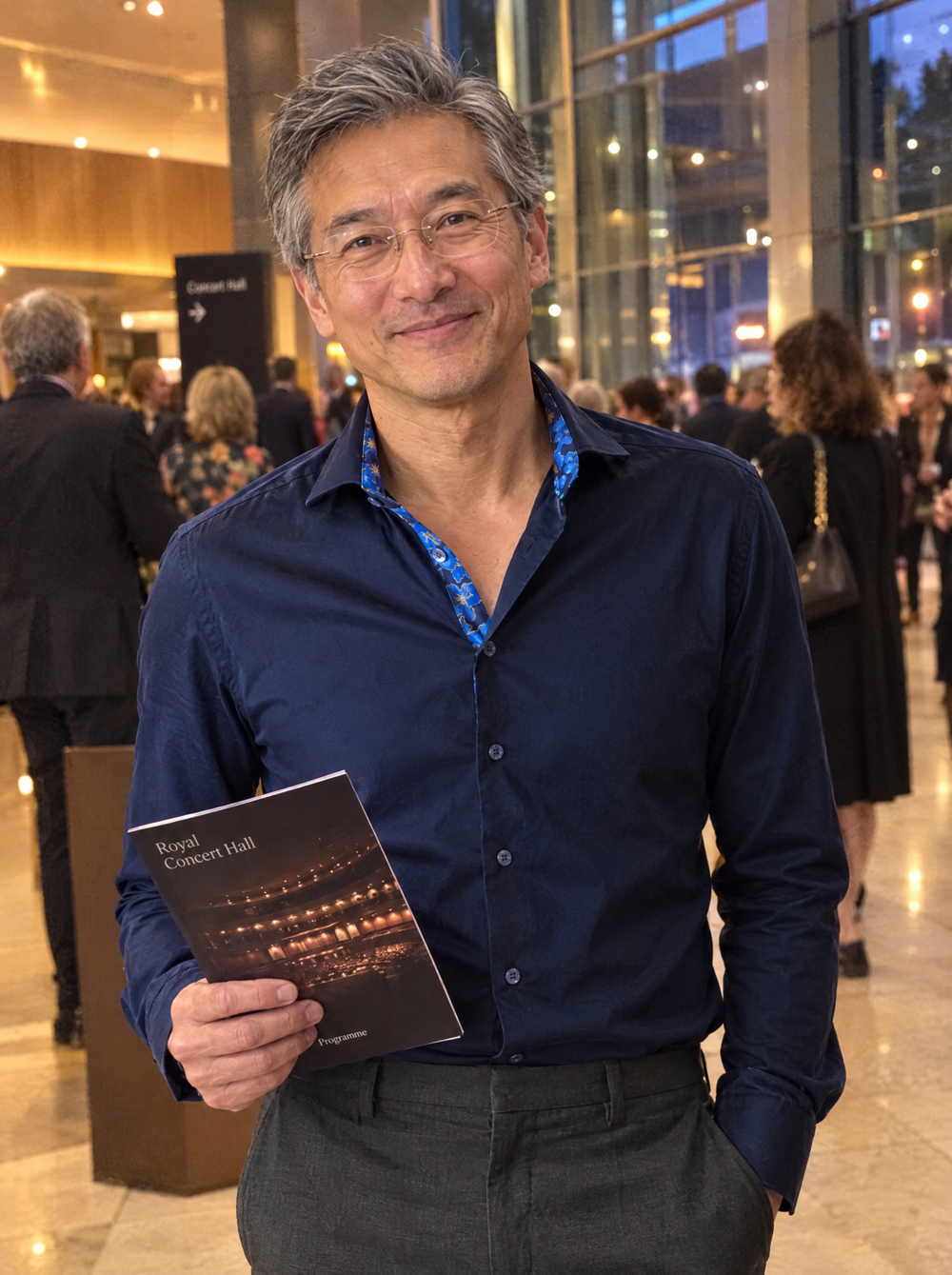 Man wearing the Navy Sateen shirt with Flowers Under Moonlight Accents in a concert hall foyer